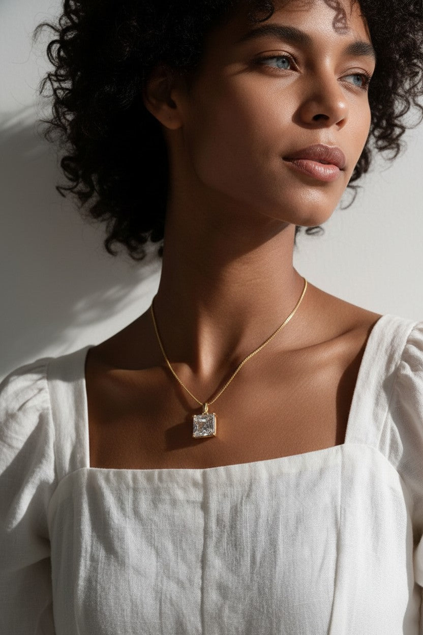 princess cut necklace on model, crystal solitaire pendant lifestyle, gold box chain necklace, square cut crystal necklace, statement pendant on model, layering necklace jewelry