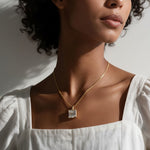 princess cut necklace on model, crystal solitaire pendant lifestyle, gold box chain necklace, square cut crystal necklace, statement pendant on model, layering necklace jewelry