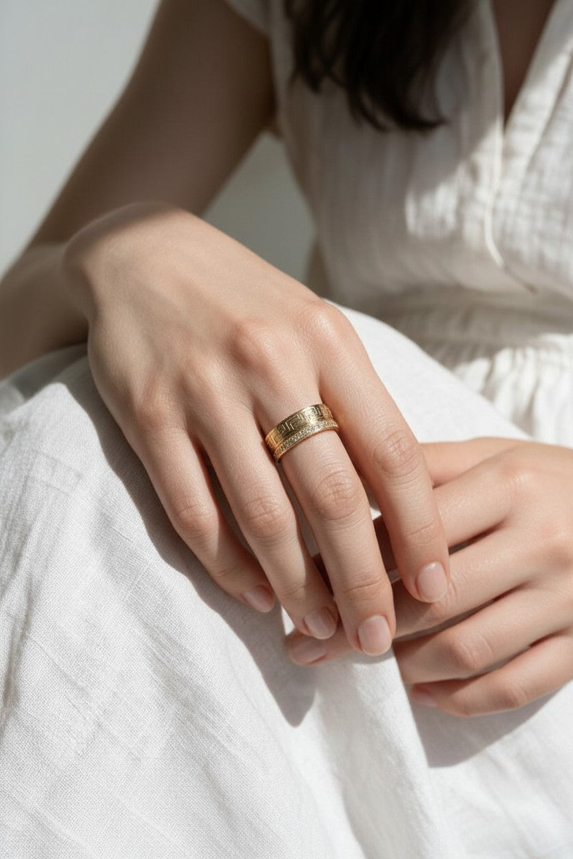 Greek key ring on model, wide gold band ring on hand, meander pattern ring, pavé band ring lifestyle, engraved gold statement ring, geometric gold band styled