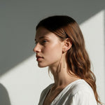 long gold rectangle earrings on model, geometric wire earrings, minimalist gold drop earrings, elongated open hoop earrings, modern gold earrings, lightweight statement earrings, architectural earrings, thin gold wire earrings, contemporary gold jewelry, linear gold earrings, women’s geometric earrings, elegant everyday earrings