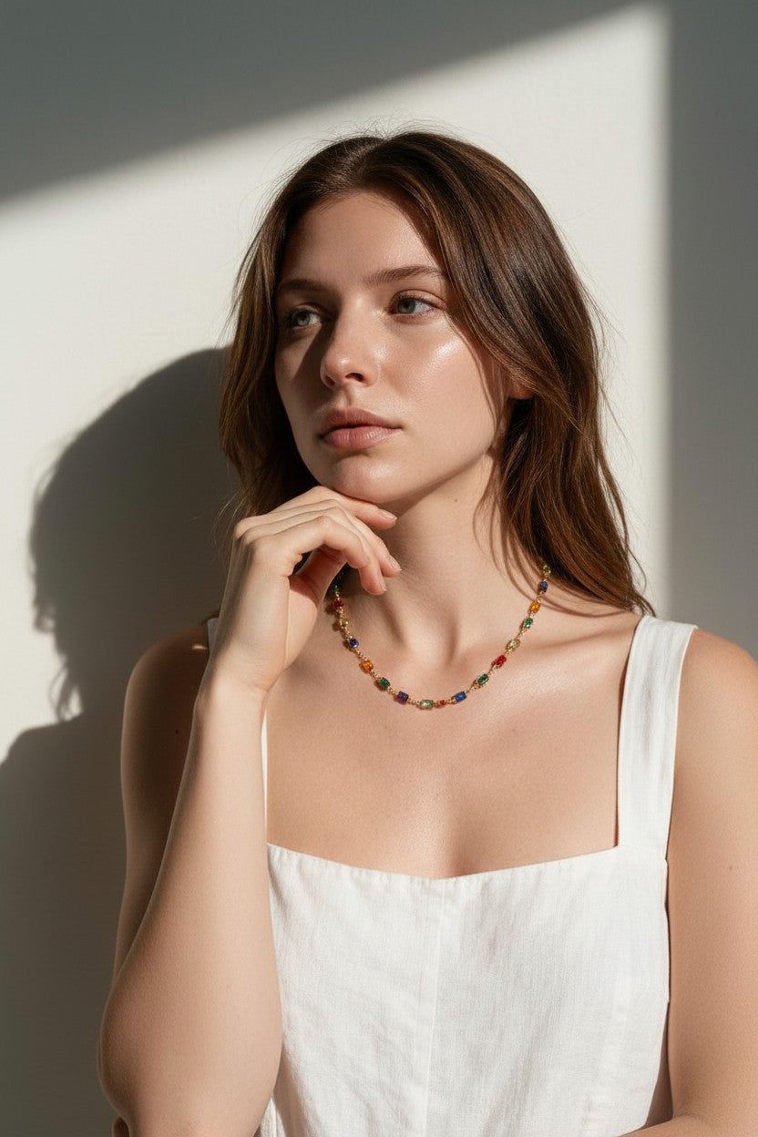 rainbow station necklace on model, colorful gemstone necklace, multicolor bezel necklace, gold station necklace, dainty colorful necklace, jewel tone necklace, emerald cut crystal necklace, summer layering necklace, collarbone length necklace, minimalist color necklace, white linen outfit jewelry, women’s rainbow necklace