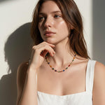 rainbow station necklace on model, colorful gemstone necklace, multicolor bezel necklace, gold station necklace, dainty colorful necklace, jewel tone necklace, emerald cut crystal necklace, summer layering necklace, collarbone length necklace, minimalist color necklace, white linen outfit jewelry, women’s rainbow necklace
