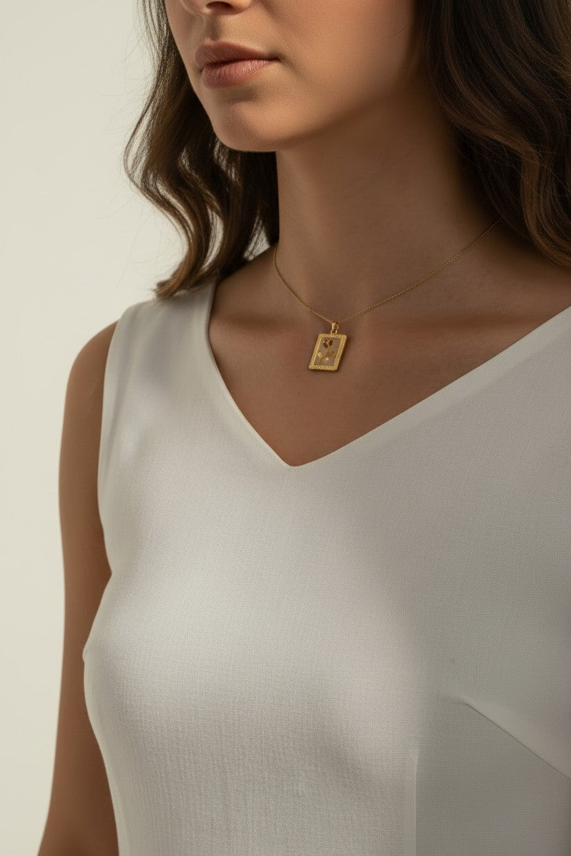 tulip pendant necklace on model, gold flower tag necklace lifestyle, botanical pendant necklace worn, engraved tulip necklace styled, dainty gold necklace on neck, CZ accent pendant, nature-inspired jewelry, rope-edge tag necklace