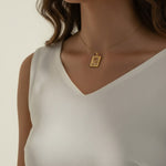 tulip pendant necklace on model, gold flower tag necklace lifestyle, botanical pendant necklace worn, engraved tulip necklace styled, dainty gold necklace on neck, CZ accent pendant, nature-inspired jewelry, rope-edge tag necklace