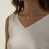 tulip pendant necklace on model, gold flower tag necklace lifestyle, botanical pendant necklace worn, engraved tulip necklace styled, dainty gold necklace on neck, CZ accent pendant, nature-inspired jewelry, rope-edge tag necklace