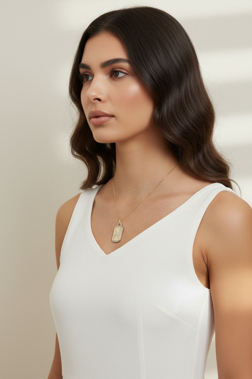 love pendant necklace on model, gold tag necklace lifestyle, sunburst pendant necklace worn, pavé love necklace styled, engraved love pendant on neck, long chain pendant necklace, statement gold necklace, script love necklace outfit