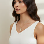 love pendant necklace on model, gold tag necklace lifestyle, sunburst pendant necklace worn, pavé love necklace styled, engraved love pendant on neck, long chain pendant necklace, statement gold necklace, script love necklace outfit