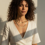 layered herringbone necklaces, double herringbone chain, gold chain layering on model, 18k gold overlay necklace set, herringbone necklace editorial, layered gold necklaces sunset, mixed length herringbone chains, gold chain styling inspiration
