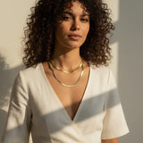 layered herringbone necklaces, double herringbone chain, gold chain layering on model, 18k gold overlay necklace set, herringbone necklace editorial, layered gold necklaces sunset, mixed length herringbone chains, gold chain styling inspiration