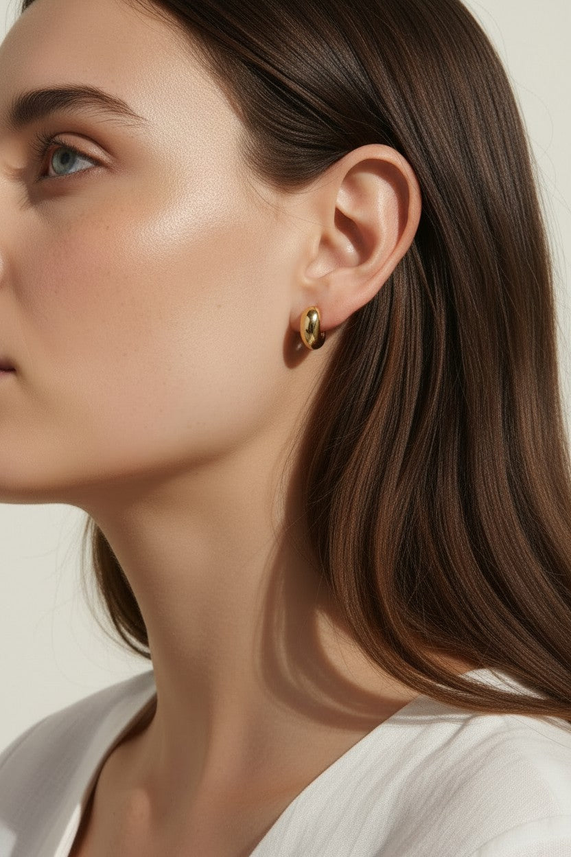 chunky gold hoop earrings, dome hoop earrings on model, puffy gold earrings, statement gold earrings, sculptural gold hoops, minimalist chunky earrings, high shine gold earrings, gold earrings close-up