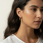 gold spike charm earrings worn, hoop earrings with charm styled, layered ear stack gold, triangle charm hoop fit, minimalist edgy earring lifestyle photo, gold ear cuff and hoop pairing