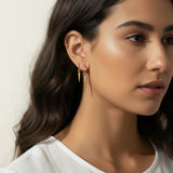 gold spike charm earrings worn, hoop earrings with charm styled, layered ear stack gold, triangle charm hoop fit, minimalist edgy earring lifestyle photo, gold ear cuff and hoop pairing