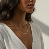 curb chain necklace on model, gold curb link necklace, classic chain necklace styled, flat link necklace worn, everyday gold necklace, polished chain necklace, layering necklace, curb chain necklace lifestyle