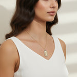 love pendant necklace on model, gold tag necklace lifestyle, sunburst pendant necklace worn, pavé love necklace styled, engraved love pendant on neck, long chain pendant necklace, statement gold necklace, script love necklace outfit