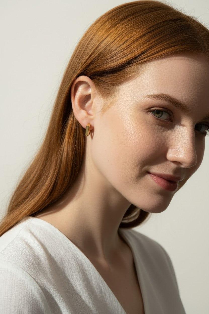 square huggie hoop earrings on model, gold geometric earrings worn, modern hoop earrings lifestyle, angular gold hoops styled, polished square earrings, minimalist huggie earrings, statement gold hoops, architectural earrings on ear