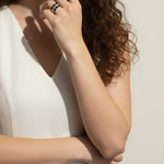 baguette eternity ring stack, gold eternity bands on model, stacked statement rings, emerald and black ring stack, layered baguette rings, gold ring stack lifestyle, colorful eternity bands worn, multi-stone ring stack