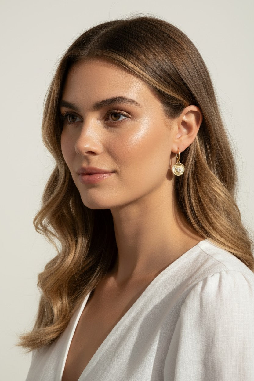sunburst disc earrings, gold drop earrings on model, heart pavé earrings, huggie hoop drop earrings, textured gold earrings, statement drop earrings, sparkle disc earrings, everyday gold earrings