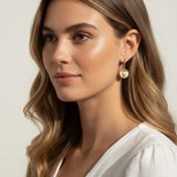 sunburst disc earrings, gold drop earrings on model, heart pavé earrings, huggie hoop drop earrings, textured gold earrings, statement drop earrings, sparkle disc earrings, everyday gold earrings