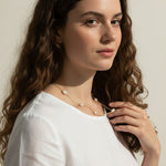 gold pearl station necklace, pearl chain necklace, freshwater pearl necklace, dainty pearl necklace on model, gold and pearl jewelry, scattered pearl necklace, layering pearl necklace, delicate pearl chain