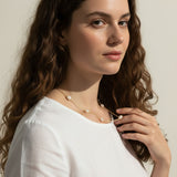 gold pearl station necklace, pearl chain necklace, freshwater pearl necklace, dainty pearl necklace on model, gold and pearl jewelry, scattered pearl necklace, layering pearl necklace, delicate pearl chain