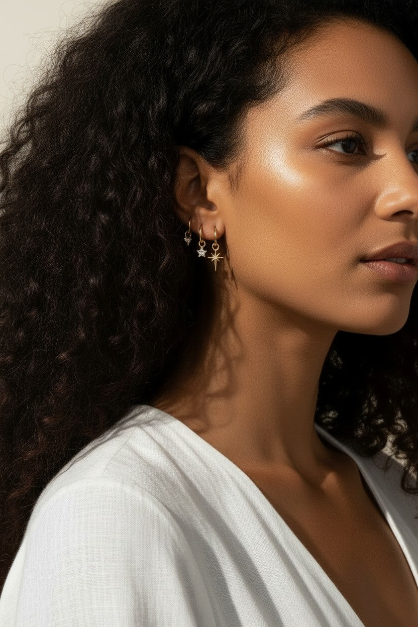 celestial charm hoop earrings worn, star and north star earring styled, layered ear stack gold, charm hoop earrings lifestyle photo, mix and match earring charms fit, gold star earring close-up