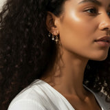 celestial charm hoop earrings worn, star and north star earring styled, layered ear stack gold, charm hoop earrings lifestyle photo, mix and match earring charms fit, gold star earring close-up