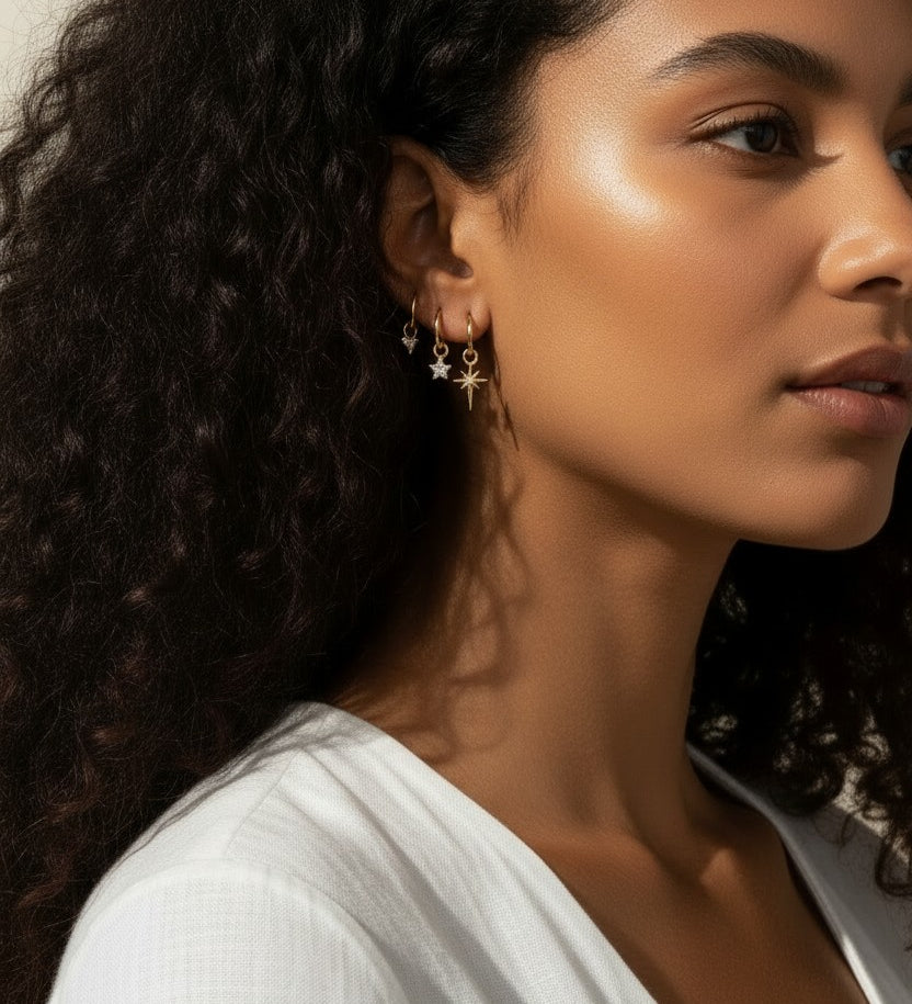 celestial charm hoop earrings worn, star and north star earring styled, layered ear stack gold, charm hoop earrings lifestyle photo, mix and match earring charms fit, gold star earring close-up