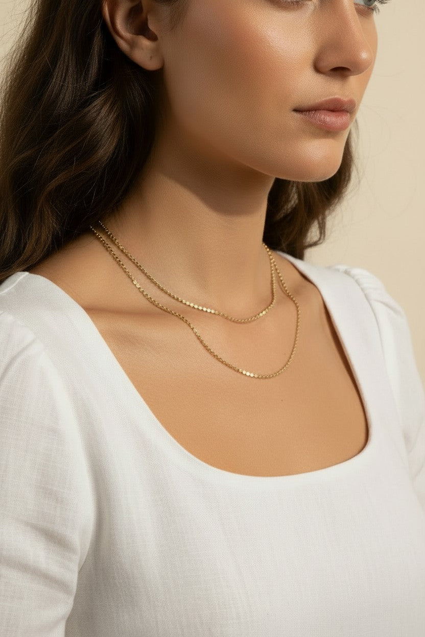 layered gold necklace set worn, double chain necklace styled, gold chain layering set fit, minimalist layered necklace lifestyle photo, disc chain and cable chain necklace, gold necklace stack close-up