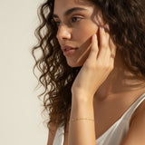 station chain bracelet on model, dainty gold bracelet lifestyle, minimalist gold bracelet, delicate chain bracelet wrist shot, 18k gold bracelet, everyday layering bracelet, gold disc bracelet, simple gold jewelry