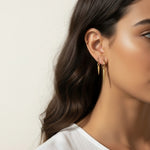 gold spike charm earrings worn, hoop earrings with charm styled, layered ear stack gold, triangle charm hoop fit, minimalist edgy earring lifestyle photo, gold ear cuff and hoop pairing
