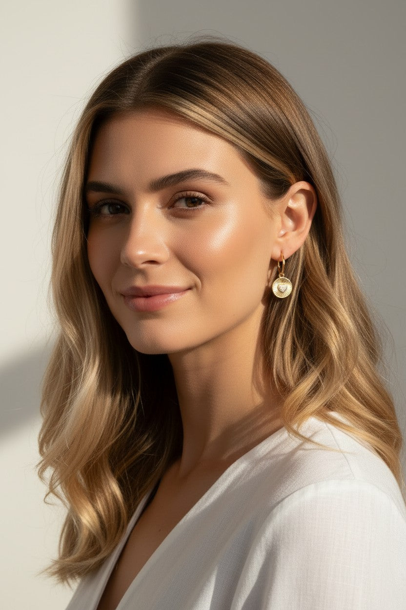 sunburst disc earrings, gold drop earrings on model, heart pavé earrings, huggie hoop drop earrings, textured gold earrings, statement drop earrings, sparkle disc earrings, everyday gold earrings