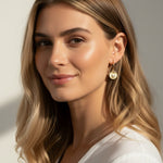 sunburst disc earrings, gold drop earrings on model, heart pavé earrings, huggie hoop drop earrings, textured gold earrings, statement drop earrings, sparkle disc earrings, everyday gold earrings