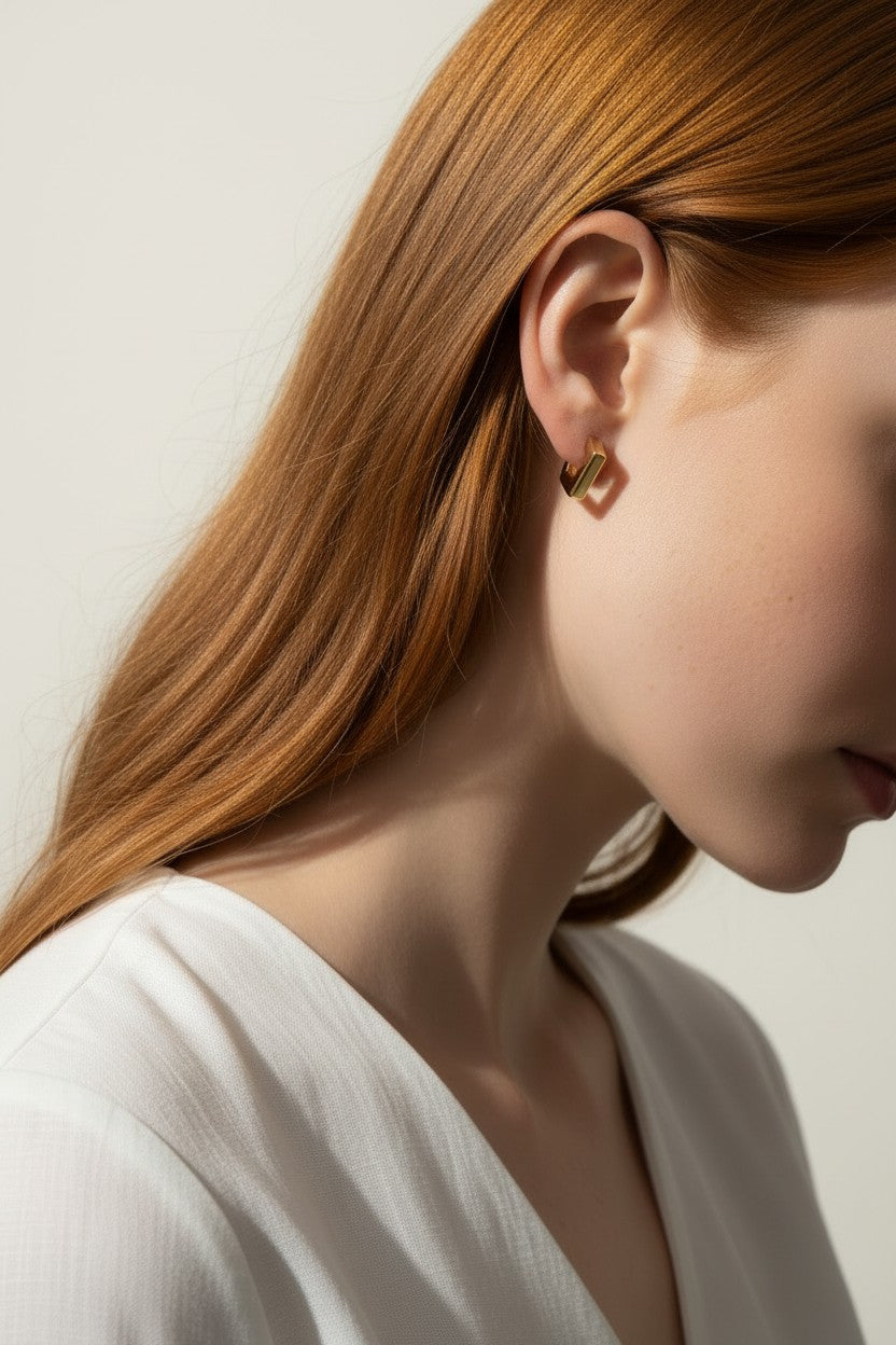 square huggie hoop earrings on model, gold geometric earrings worn, modern hoop earrings lifestyle, angular gold hoops styled, polished square earrings, minimalist huggie earrings, statement gold hoops, architectural earrings on ear
