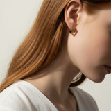 square huggie hoop earrings on model, gold geometric earrings worn, modern hoop earrings lifestyle, angular gold hoops styled, polished square earrings, minimalist huggie earrings, statement gold hoops, architectural earrings on ear