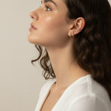 gold beaded huggie hoops, small gold hoop earrings, stacked ear look, beaded hoop earrings, layered earring set, gold huggie hoops on model, dainty gold hoops, curated ear stack