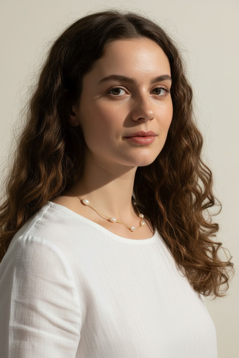 gold pearl station necklace, pearl chain necklace, freshwater pearl necklace, dainty pearl necklace on model, gold and pearl jewelry, scattered pearl necklace, layering pearl necklace, delicate pearl chain