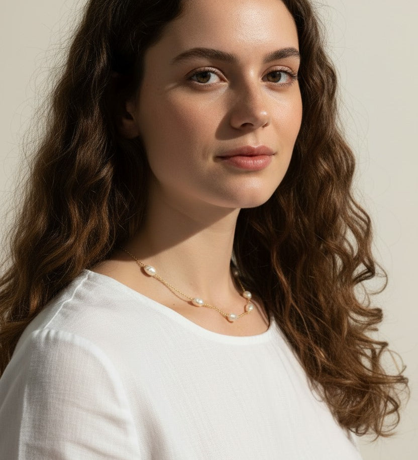 gold pearl station necklace, pearl chain necklace, freshwater pearl necklace, dainty pearl necklace on model, gold and pearl jewelry, scattered pearl necklace, layering pearl necklace, delicate pearl chain