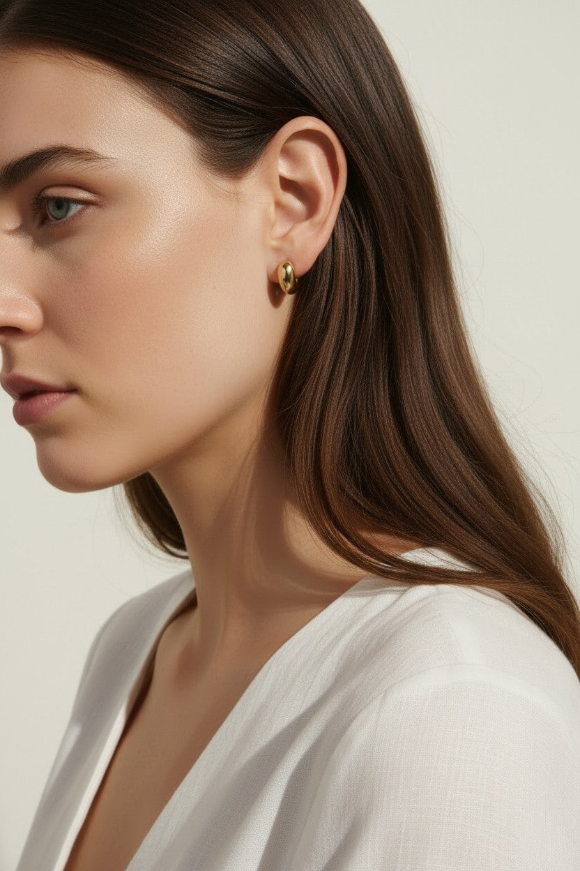 chunky gold hoop earrings, dome hoop earrings on model, puffy gold earrings, statement gold earrings, sculptural gold hoops, minimalist chunky earrings, high shine gold earrings, gold earrings close-up