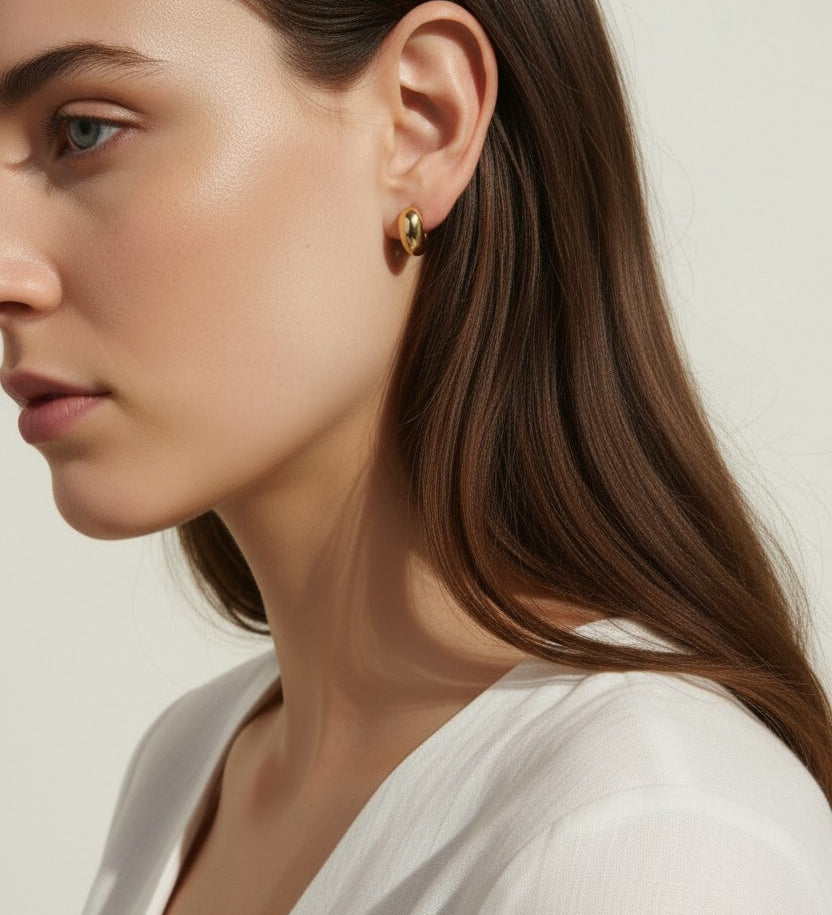 chunky gold hoop earrings, dome hoop earrings on model, puffy gold earrings, statement gold earrings, sculptural gold hoops, minimalist chunky earrings, high shine gold earrings, gold earrings close-up