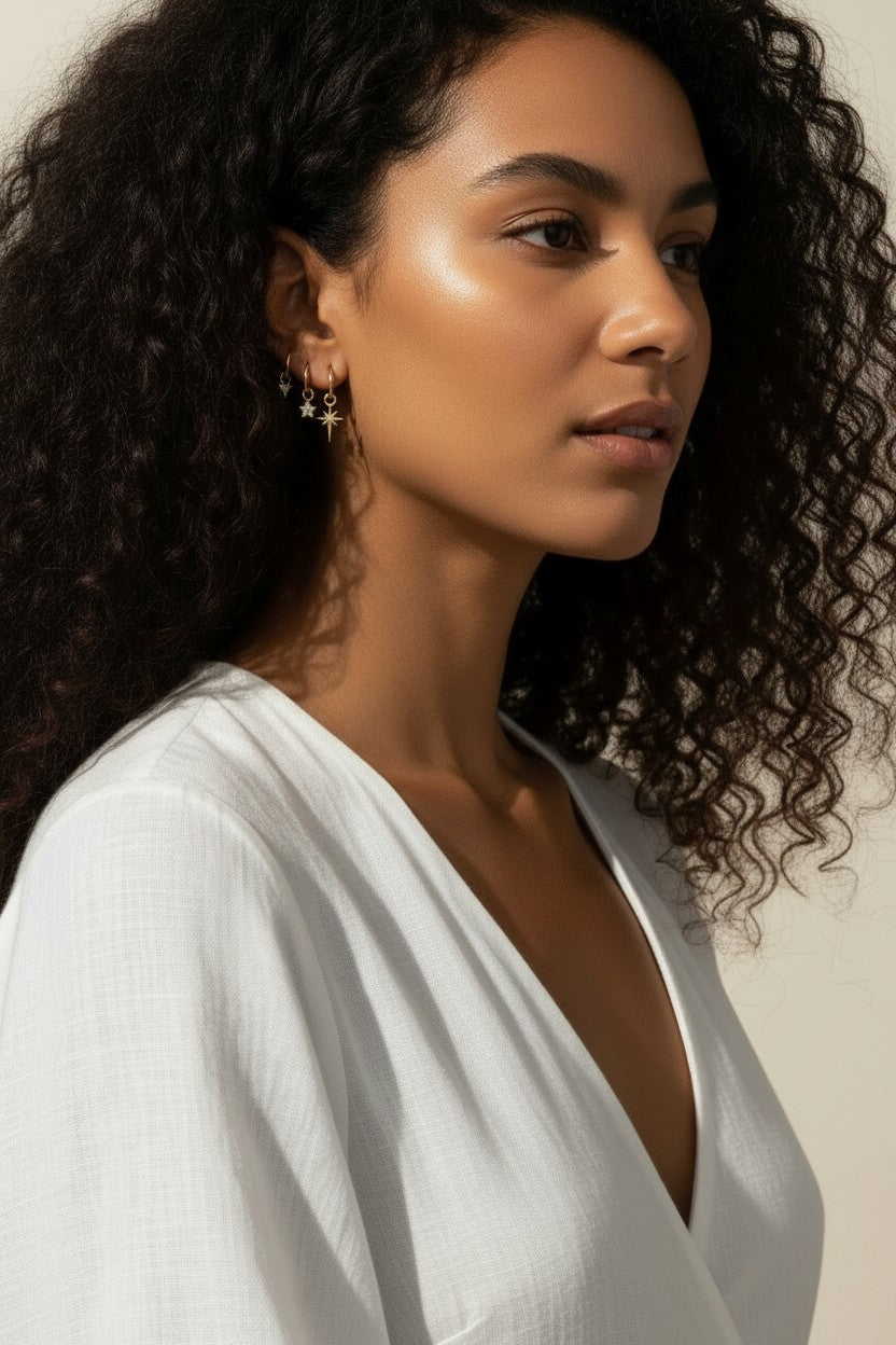 celestial charm hoop earrings worn, star and north star earring styled, layered ear stack gold, charm hoop earrings lifestyle photo, mix and match earring charms fit, gold star earring close-up