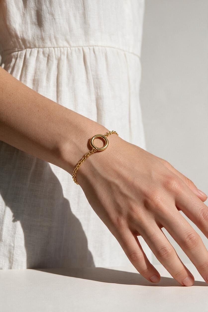gold rolo chain bracelet on wrist, round clasp bracelet, charm holder bracelet, spring ring clasp bracelet, gold chain bracelet with ring, minimalist gold bracelet, modern gold bracelet, layering bracelet, everyday gold bracelet, interchangeable charm bracelet, circle clasp bracelet, women’s gold bracelet