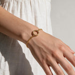 gold rolo chain bracelet on wrist, round clasp bracelet, charm holder bracelet, spring ring clasp bracelet, gold chain bracelet with ring, minimalist gold bracelet, modern gold bracelet, layering bracelet, everyday gold bracelet, interchangeable charm bracelet, circle clasp bracelet, women’s gold bracelet