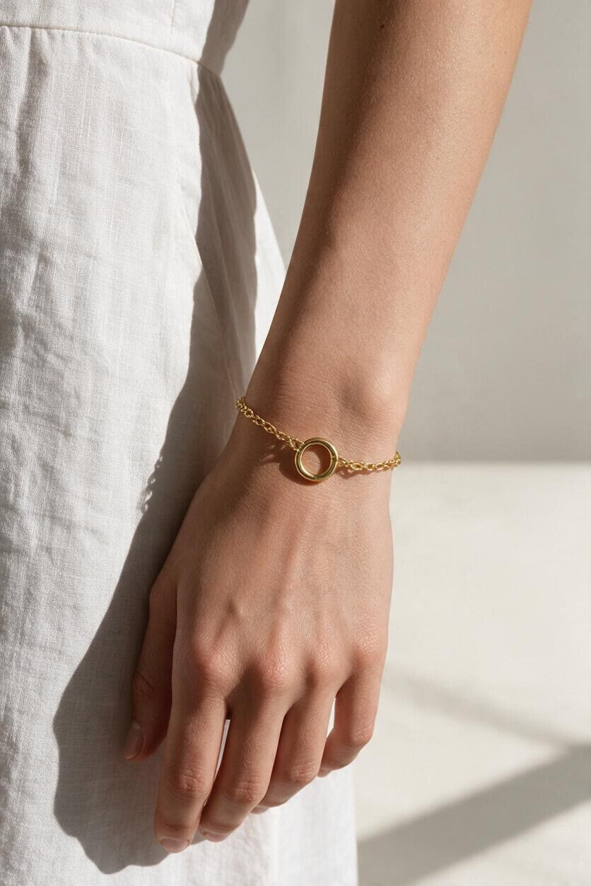 gold rolo chain bracelet on wrist, round clasp bracelet, charm holder bracelet, spring ring clasp bracelet, gold chain bracelet with ring, minimalist gold bracelet, modern gold bracelet, layering bracelet, everyday gold bracelet, interchangeable charm bracelet, circle clasp bracelet, women’s gold bracelet