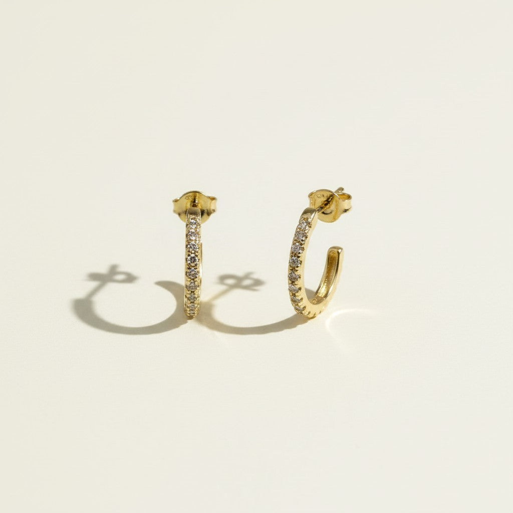 pavé huggie hoop earrings, gold huggie earrings flat lay, small pavé hoop earrings, sparkle hoop earrings detail, hinged huggie hoops, everyday gold hoops, ear stack earrings, minimalist gold hoops