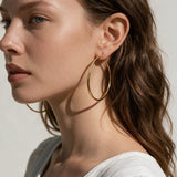 large thin gold hoop earrings on model, big gold hoops, thin wire hoop earrings, endless hoop earrings, classic gold hoops, lightweight large hoops, minimalist hoop earrings, everyday gold hoops, statement hoops, sleeper hoops, summer hoop earrings, gift for her