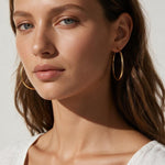 large thin gold hoop earrings on model, big gold hoops, thin wire hoop earrings, endless hoop earrings, classic gold hoops, lightweight large hoops, minimalist hoop earrings, everyday gold hoops, statement hoops, sleeper hoops, summer hoop earrings, gift for her