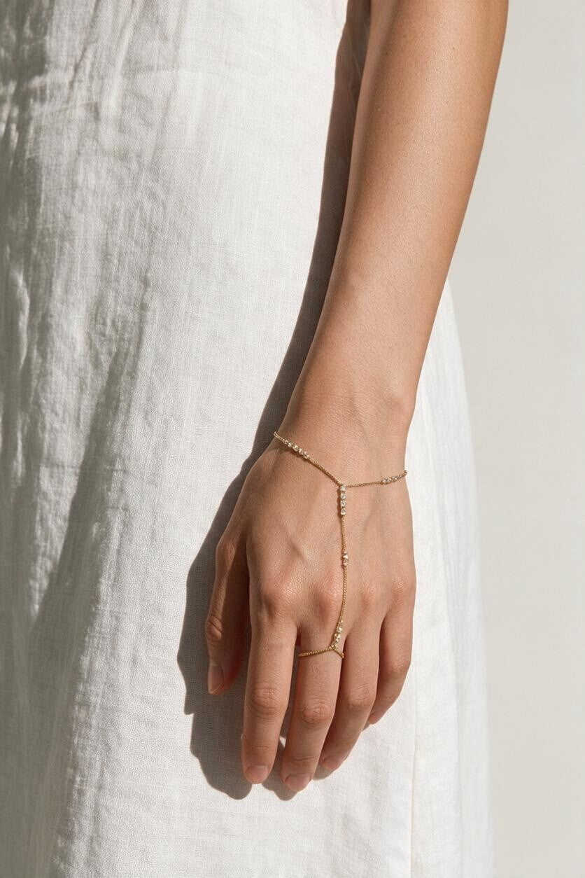 gold hand chain bracelet on model, slave bracelet, finger ring bracelet, hand harness jewelry, crystal hand chain, bridal hand chain, bracelet with ring attached, dainty gold hand chain, delicate hand jewelry, party hand jewelry, wedding hand chain, women’s hand chain