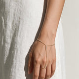 gold hand chain bracelet on model, slave bracelet, finger ring bracelet, hand harness jewelry, crystal hand chain, bridal hand chain, bracelet with ring attached, dainty gold hand chain, delicate hand jewelry, party hand jewelry, wedding hand chain, women’s hand chain