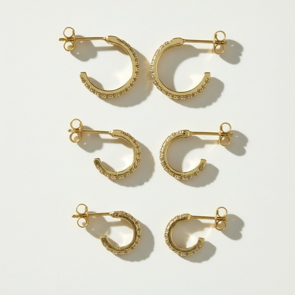 pavé huggie hoop earrings, gold huggie earrings flat lay, small pavé hoop earrings, sparkle hoop earrings detail, hinged huggie hoops, everyday gold hoops, ear stack earrings, minimalist gold hoops