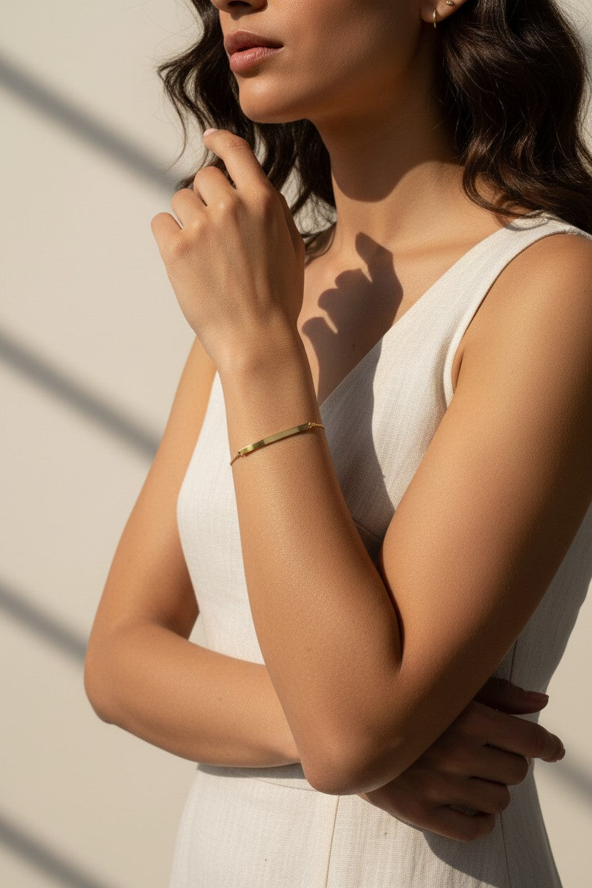 gold bar cuff bracelet on model, minimalist gold cuff worn, thin gold bracelet fit, editorial jewelry photo, gold bracelet wrist close-up, sunlit jewelry lifestyle shot